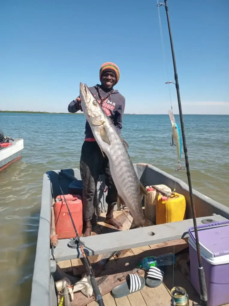 Un pêcheur de Ngor présentant fièrement une grosse prise à bord de sa pirogue